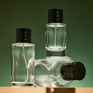 Detail shot of clear glass empty perfume spray bottles with black caps on wooden shelf.