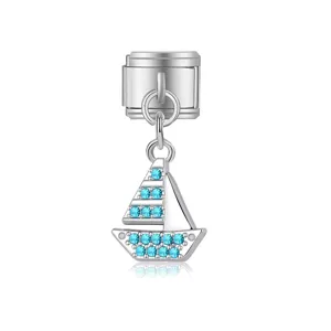 Detalle de charm italiano con un velero plateado y cristalli azul.