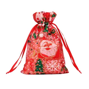 Sachet cadeau de Noël rouge avec cordon et motifs festifs de Père Noël et d'arbres.
