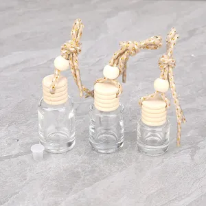 Flacon de parfum de voiture en verre transparent vide à suspendre avec bouchon en bois et perle.