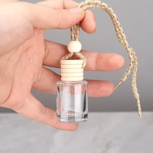 Gros plan détaillé d'un flacon de parfum de voiture en verre transparent et bois.