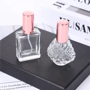 Glass perfume atomizer detail shot, transparent sub bottle with pink spray cap for travel use.