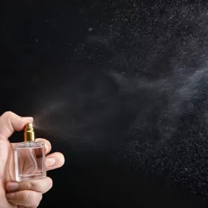 Fine mist spray detail of 15ml clear glass perfume bottle with gold pump dispenser.