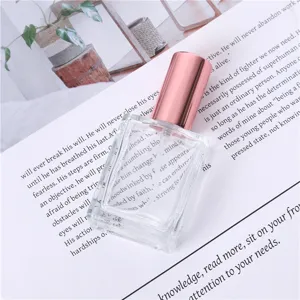 Portable 15ml clear glass perfume spray bottle with rose gold cap for travel cosmetics.