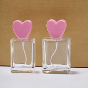 Viereckige Glas-Parfümflasche mit rosafarbenem Herzdeckel und einem praktischen Sprühzerstäuber.