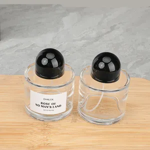 Detailansicht der 100ml klaren Glas-Parfümflasche mit schwarzem runden Deckel und Sprühkopf.