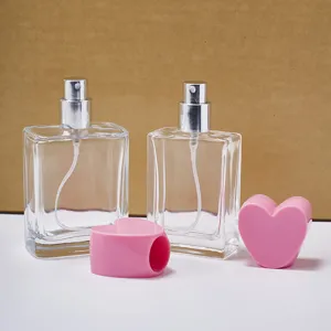 Klare quadratische Glas-Parfümflaschen mit rosa Herz-Kappen, leere nachfüllbare Sprühflaschen.