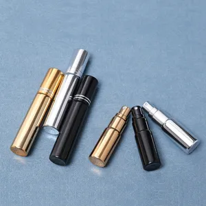 Gros plan de vaporisateurs de parfum rechargeables portables en métal doré, argenté et noir.