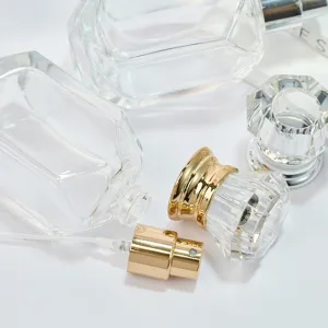 Detail view of 50ml empty glass perfume bottle with gold spray pump and crystal cap.