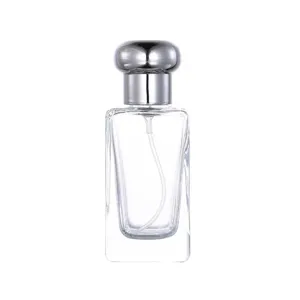 Detailed view of a clear glass perfume bottle with a silver cap, ideal for cosmetic sampling.