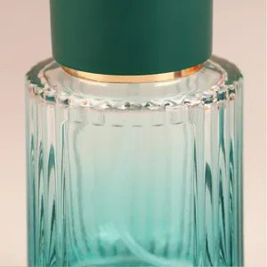 Primo piano dettagliato di un elegante flacone di profumo in vetro verde a righe verticali.