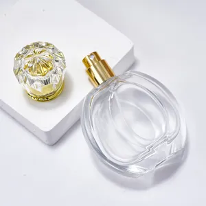 Close-up detail of clear glass perfume bottle with golden spray pump and diamond cap.