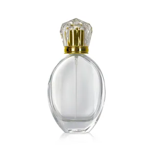 Clear glass perfume bottle detail view, diamond shaped golden cap and spray nozzle.