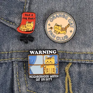 Detailopname van grappige oranje katten emaille pins op denim, thema kantoor en club