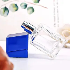 Tragbare 30ml klare Glas-Parfümflasche mit blauem asymmetrischem Deckel und Sprühkopf für Reisekosmetik.