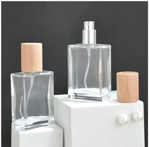 Clear square glass perfume bottle detail view with wooden cap and spray nozzle for home use.