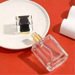 Détail de flacon de parfum en verre rechargeable avec buse de pulvérisation dorée.