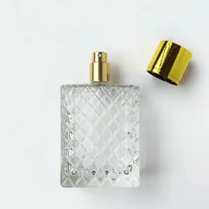 Nahaufnahme der klaren Glasparfümflasche mit elegantem Rautenmuster und goldener Kappe.