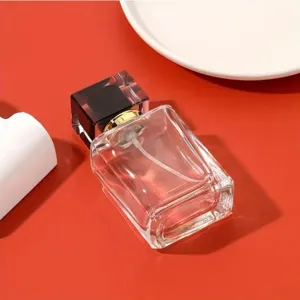 Gros plan d'un flacon de parfum en verre vide de 50ml avec bouchon noir et buse dorée.