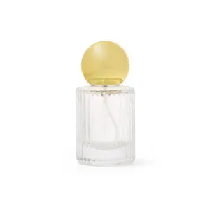 Transparant geribbeld glazen parfumflesje detail met gepolijste gouden bolkop en fijne sproeier.