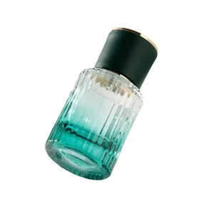 Gradient glass perfume spray bottle detail view, elegant ribbed design with dark cap.