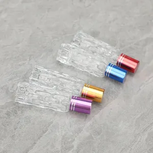 Dettaglio flacone roll-on in vetro per oli essenziali, superficie testurizzata e tappi.