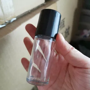 Gros plan détail d'un flacon à bille en verre transparent avec un beau bouchon noir.