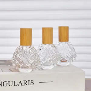 Vue détaillée de flacons à bille en verre transparent de 15ml avec couvercles en bambou.