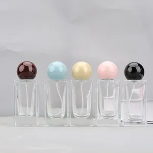 Square glass perfume spray bottle featuring a colorful round ball cap and portable design detail.