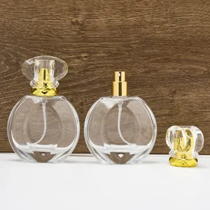 Clear glass refillable perfume bottle detail, 50ml empty cosmetic container with gold spray pump.