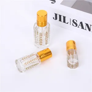 Clear glass essential oil roller bottles with gold caps and elegant leaf patterns for travel.