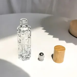 Détail de flacon roll-on en verre transparent, bouchon en bois naturel et bille d'acier.