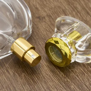 Detailed close-up of empty 50ml refillable perfume glass bottle with gold nozzle and cap.