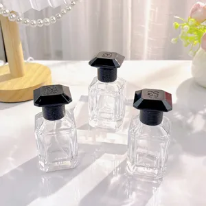 Transparente quadratische Glas-Parfümflasche mit schwarzem facettierten Deckel, 30ml.