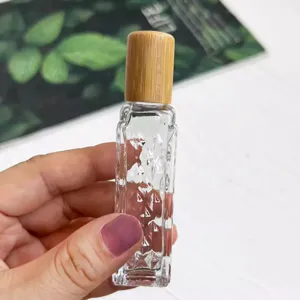 Vue détaillée d'un flacon roll-on en verre avec motif losange et bouchon en bambou naturel.