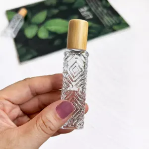 Flacon roll-on en verre transparent avec bouchon en bambou, texture gaufrée pour huile essentielle.