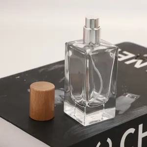 Detail shot of clear glass perfume bottle with wooden cap and silver spray pump nozzle.