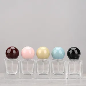 Detail view of square glass perfume spray bottles with colorful round ball caps, 5-piece set.