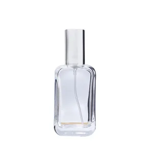 Detail shot of transparent glass perfume bottle with silver pump, empty refillable sample container.
