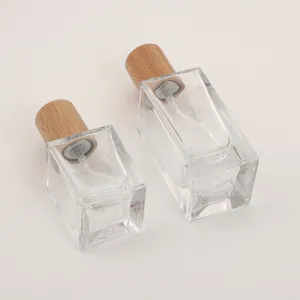 Glass perfume bottle detail showcasing clear square glass body and natural wooden cap design.