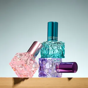 Primer plano detallado del frasco de perfume de vidrio cubo colorido de 10 ml con atomizador fino.