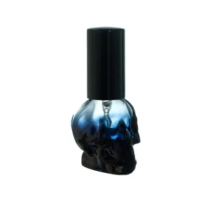 Nahaufnahme der blauen Farbverlauf-Totenkopf-Glas-Parfümsprühflasche mit schwarzem Deckel.