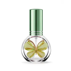 Detailaufnahme einer runden 10ml Glas-Parfümflasche mit grünem Deckel und Schmetterling.