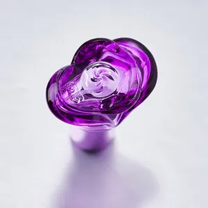Vista detallada de un tapón de botella de perfume de vidrio violeta, con diseño de rosa.