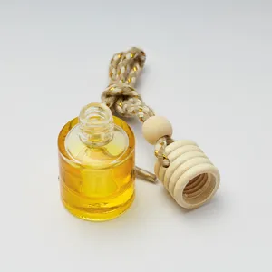 Clear glass car perfume bottle with yellow liquid, wooden cap and woven hanging rope.