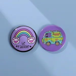 Close-up of circular cartoon tinplate badges with Mystery Machine and cat paw designs
