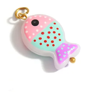 Close-up of a colorful glass fish pendant with polka dots for DIY jewelry.