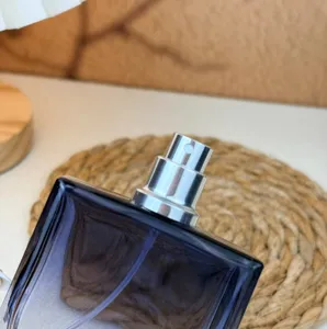Primo piano di dettaglio di un flacone di profumo in vetro quadrato sfumato con spruzzatore.