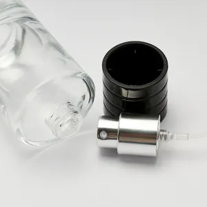 Clear glass perfume bottle component detail, empty refillable spray bottle with pump and cap.