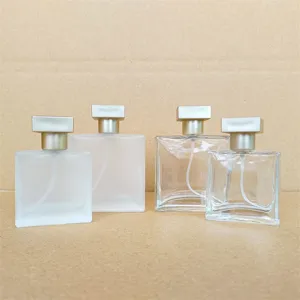 Close-up view of square glass perfume bottles, featuring frosted and clear designs with silver caps.